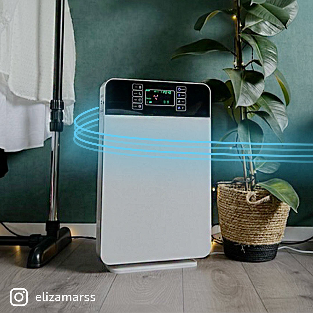 Der Livington Air Purifier steht im modernen Raum neben einer Pflanze und reinigt die Luft.