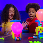 Zwei Kinder spielen begeistert mit dem farbenfrohen Balloon Zoom und beobachten aufblasende Ballons.