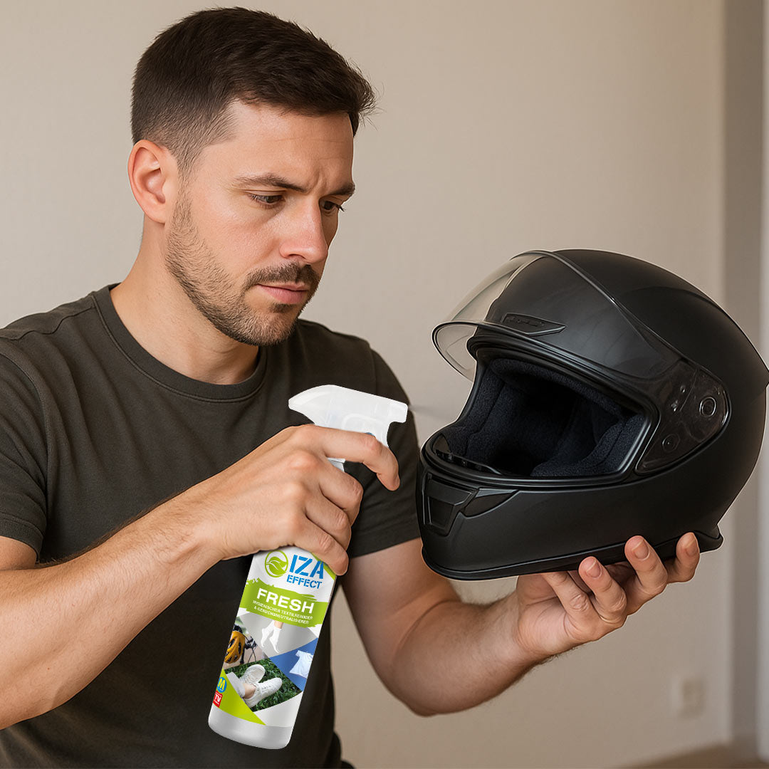 Mann sprüht Helm-Innenraum mit Reinigungsspray ein.