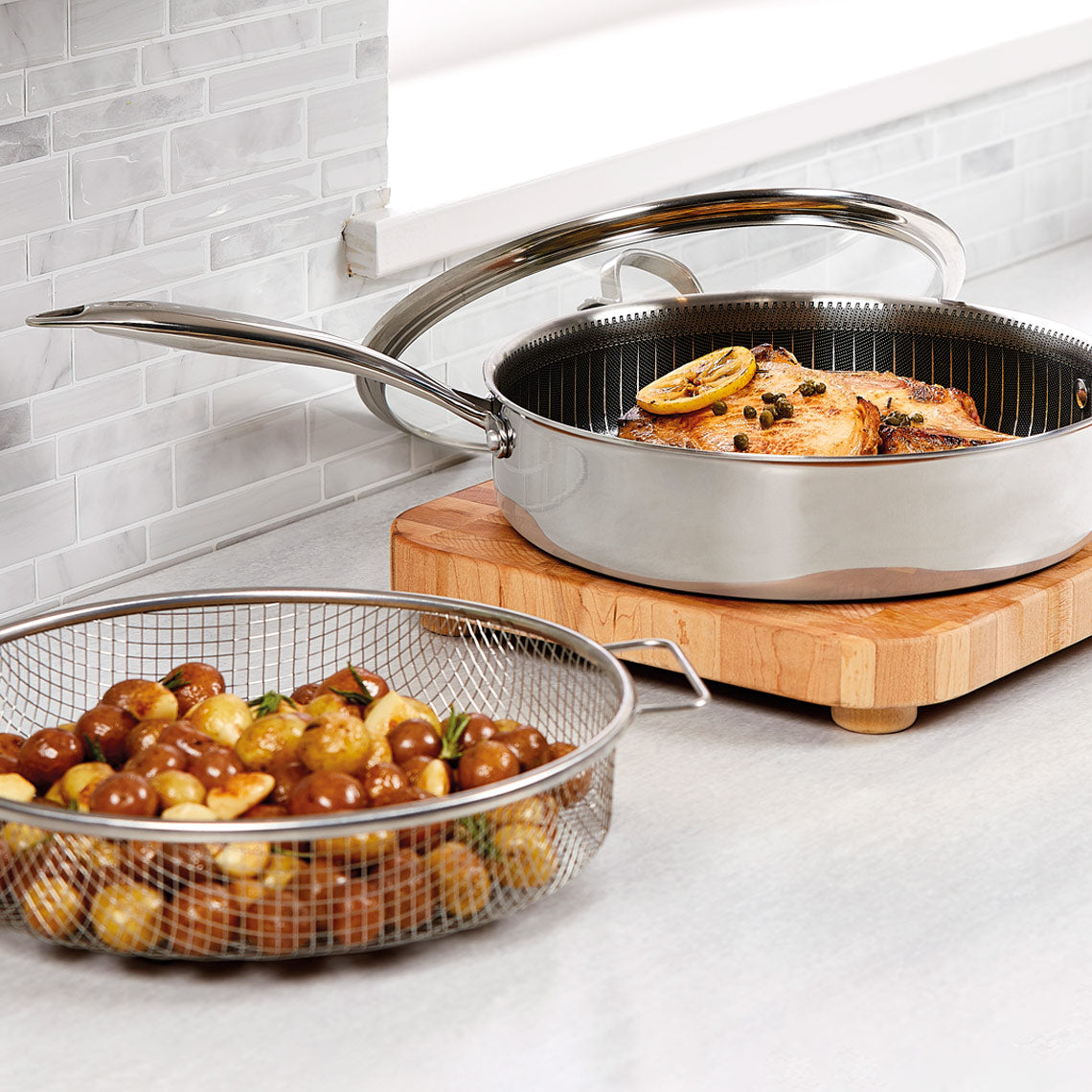 Die Livington Titan Pan mit Frittierkorb zeigt gebratenes Hähnchen und Kartoffeln – ideal für knusprige und gesunde Zubereitung.