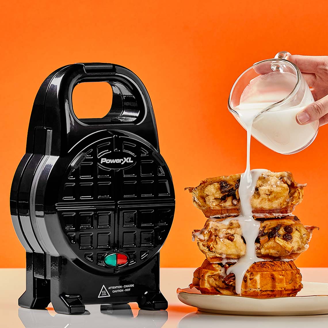 PowerXL Waffle Star mit fertigen Waffeln, die mit Sahne übergossen werden – für perfekte Waffelgenüsse.