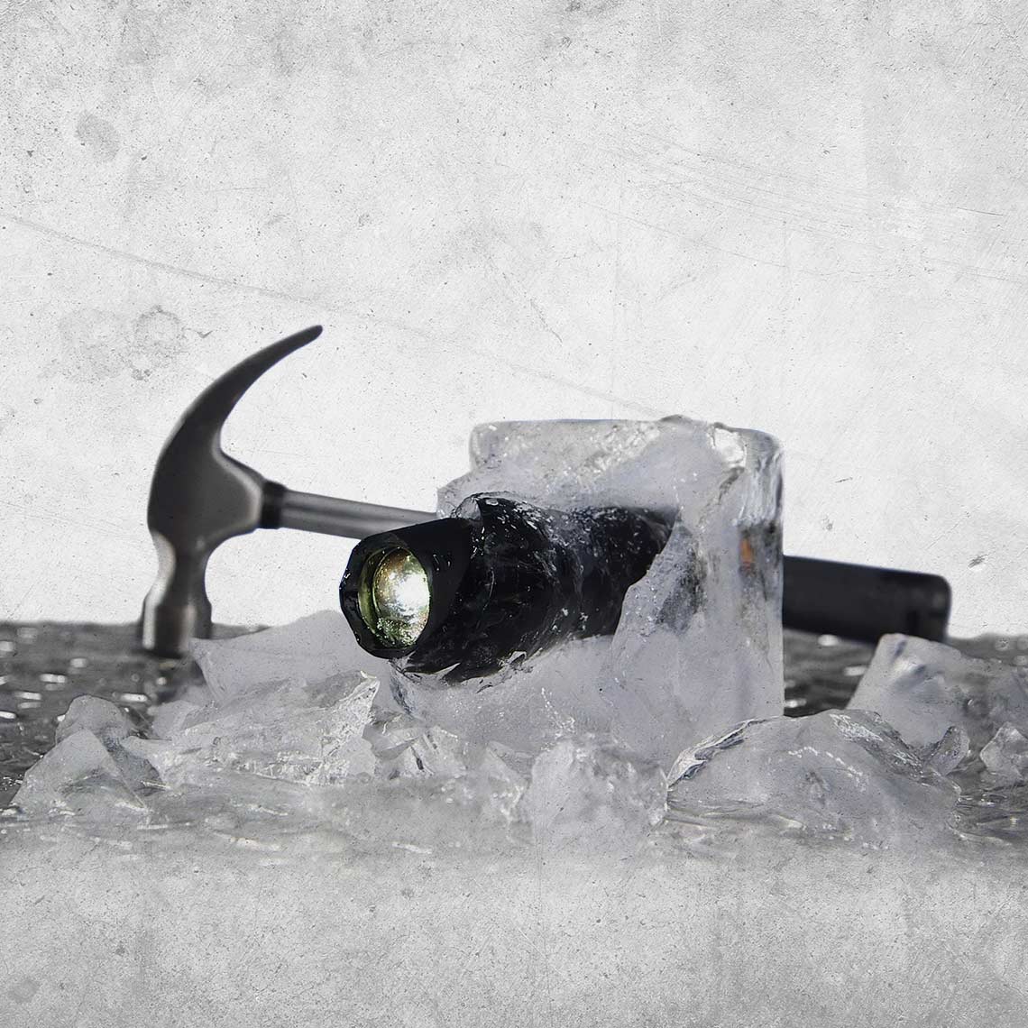 Tac Light im Eisblock mit Hammer – zeigt extreme Kältebeständigkeit.