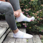 Neuro Socks Athletic – weiße Sportsocken werden vor dem Training im Freien angezogen.