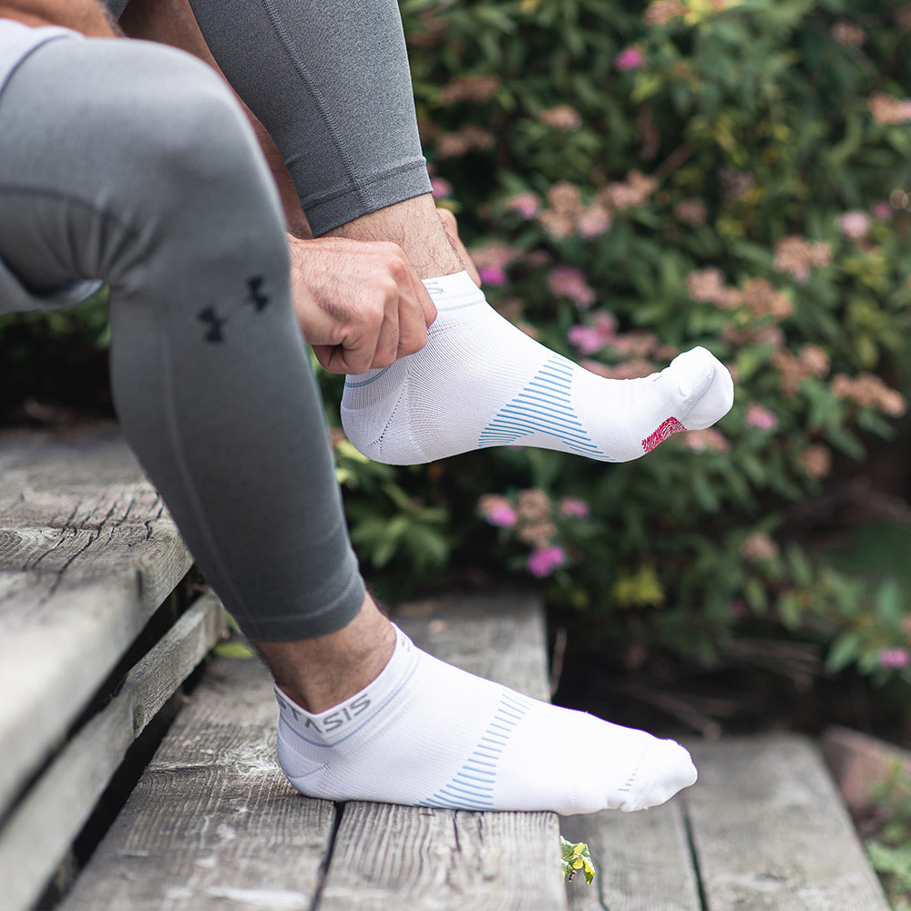 Neuro Socks Athletic – weiße Sportsocken werden vor dem Training im Freien angezogen.