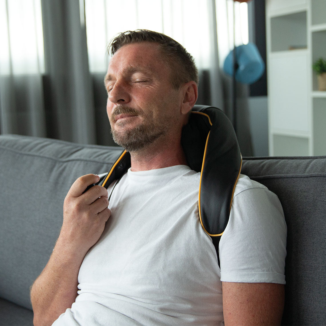 Mann entspannt mit Nackenmassage-Gerät
