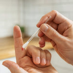 Person behandelt eine kleine Schnittwunde am Finger mit dem ClicSwab Blutstopper