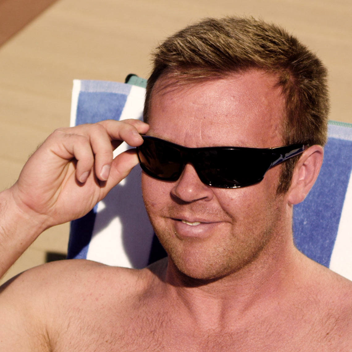 Ein Mann trägt eine HD Polar View Sonnenbrille und sitzt entspannt in der Sonne.