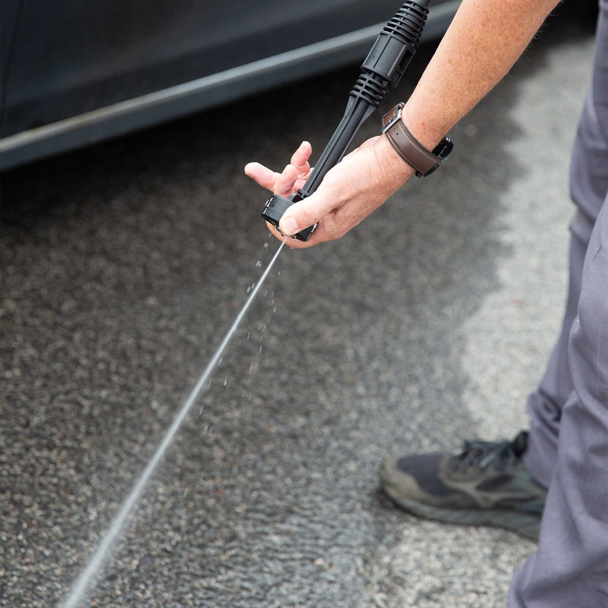 Reinigung mit dem Hammersmith HydroBlast MAX – starker Wasserstrahl auf Asphalt neben einem Auto