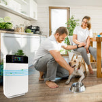 Paar mit Hund in heller Küche, im Vordergrund der Livington Air Purifier zur Luftreinigung.