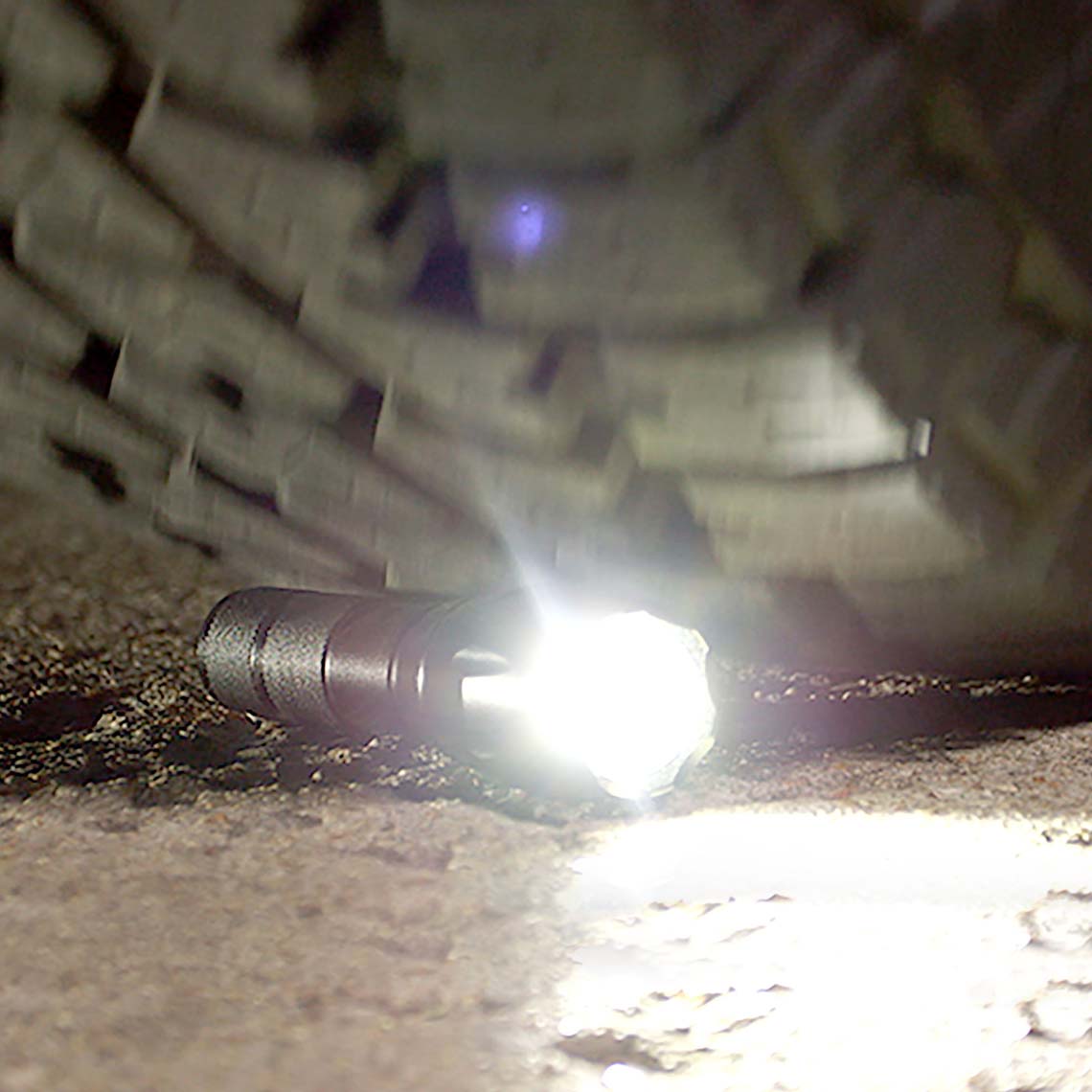 Tac Light wird von Autoreifen überrollt – bleibt funktionstüchtig, zeigt hohe Robustheit.