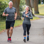 Neuro Socks Athletic – aktives Paar beim Joggen im Park, trägt funktionelle Sportsocken.