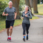 Neuro Socks Athletic – sportliches Paar joggt im Park und trägt Sportsocken.