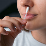 Frau trägt mit einem ClicSwab Lippenpflege-Stäbchen gezielt Pflege auf eine Fieberblase unter der Nase auf