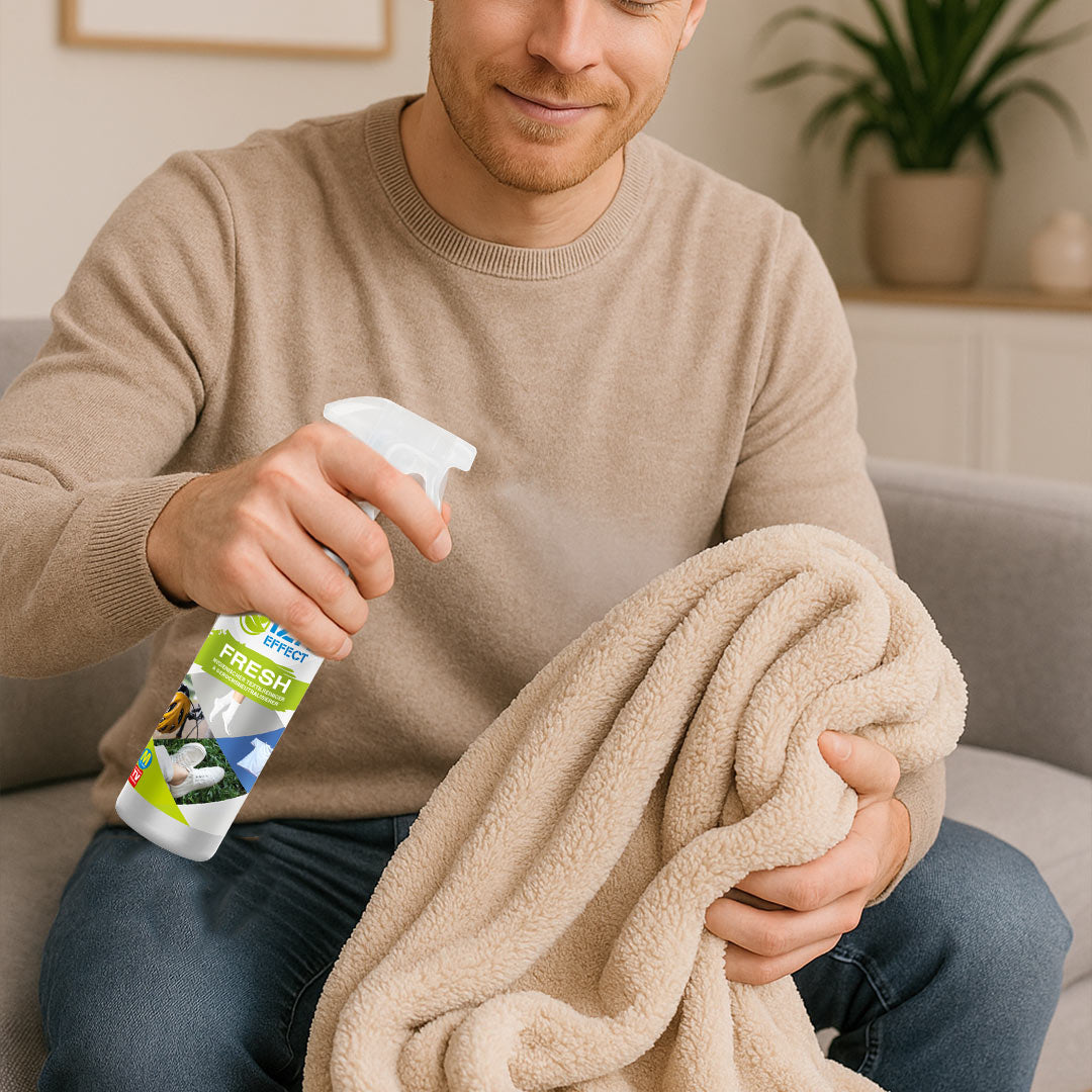 Mann sprüht Decke mit Frischespray ein.