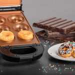 Livington FlipSwitch mit Einsatz für Mini-Donuts. Zwei Donuts sind gebacken, andere bunt verziert auf einem Teller.