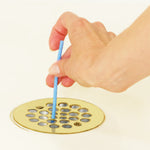 Ein Sani Stick wird in den Abfluss einer Dusche eingeführt – zur Vorbeugung von Verstopfungen und Gerüchen.