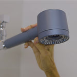 Hand drückt Wasserstopptaste auf modernen Duschaufsatz – hochwertige, ergonomische Brause in Nahaufnahme.