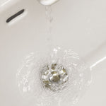 Wasser läuft in ein Waschbecken mit eingesetztem Drain Magic Universalstöpsel und fließt problemlos ab