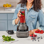 Frau mixt frische Zutaten im PowerXL SensiMax Blender auf der Küchenzeile