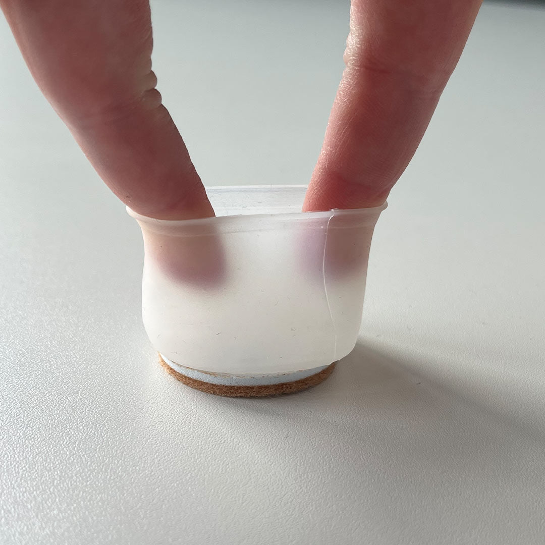 Stuhlkappe wird mit zwei Fingern auseinander gedehnt um die Flexibilität des Materials zu zeigen