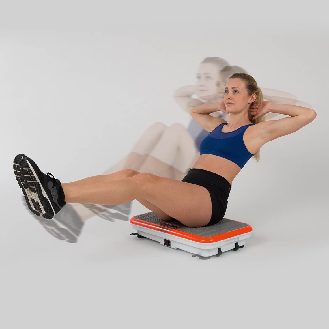 Frau trainiert ihre Bauchmuskeln im Sitzen auf der VibroShaper Deluxe Vibrationsplatte.