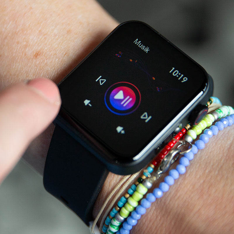 Der Kendox LifeTracker wird zur Musiksteuerung genutzt, das Display zeigt Play- und Skip-Funktionen.