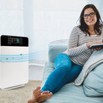 Frau entspannt auf dem Sofa mit Tablet, daneben der Livington Air Purifier zur Luftreinigung.