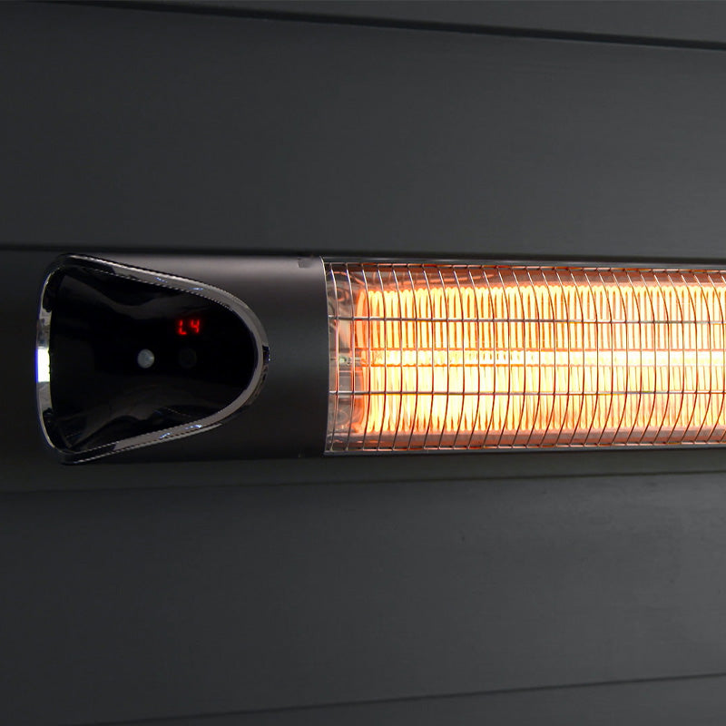 Nahaufnahme des eingeschalteten Livington Instant Heater an einer dunklen Wand montiert.