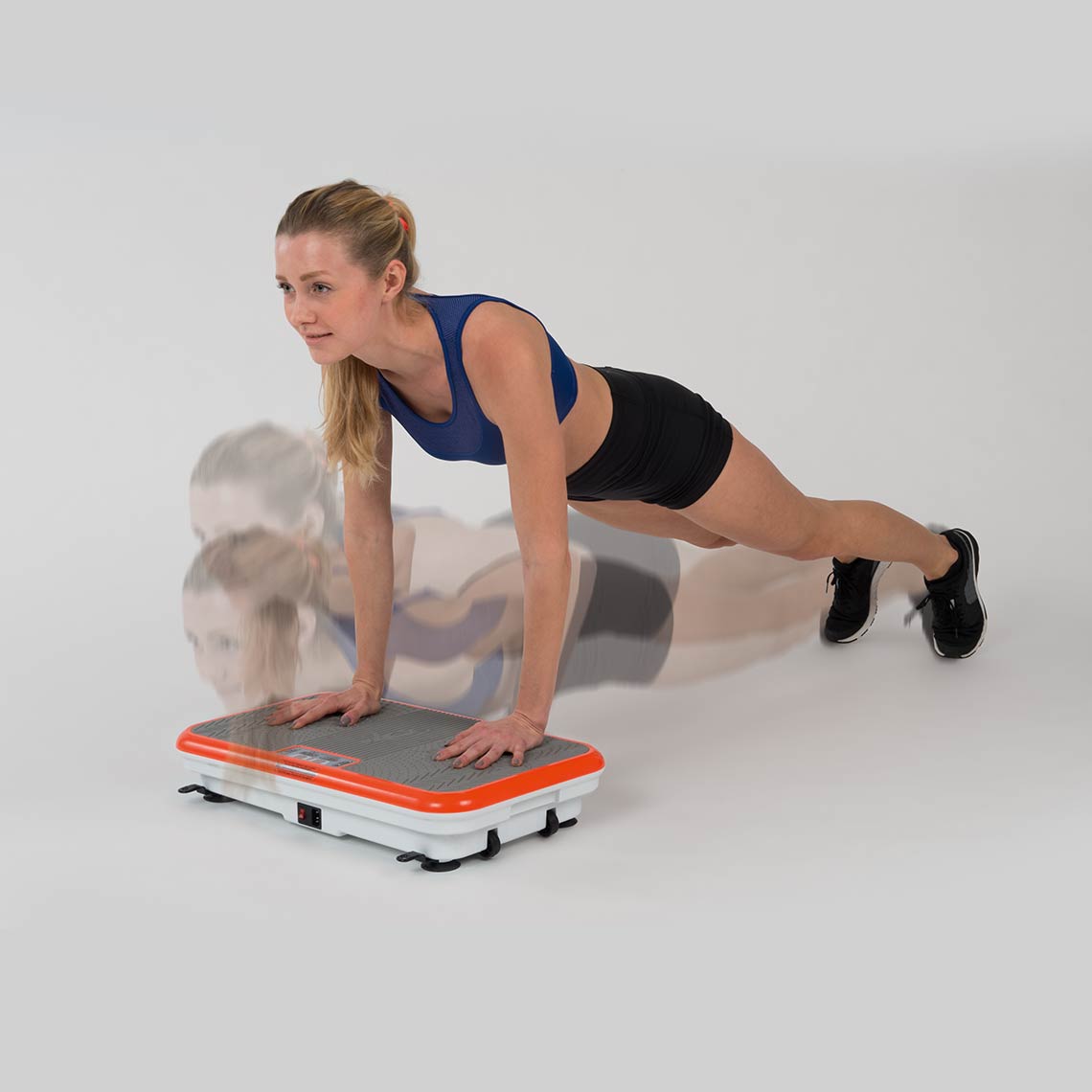 Frau macht Liegestütze auf der VibroShaper Deluxe Vibrationsplatte zur Kräftigung des Oberkörpers.