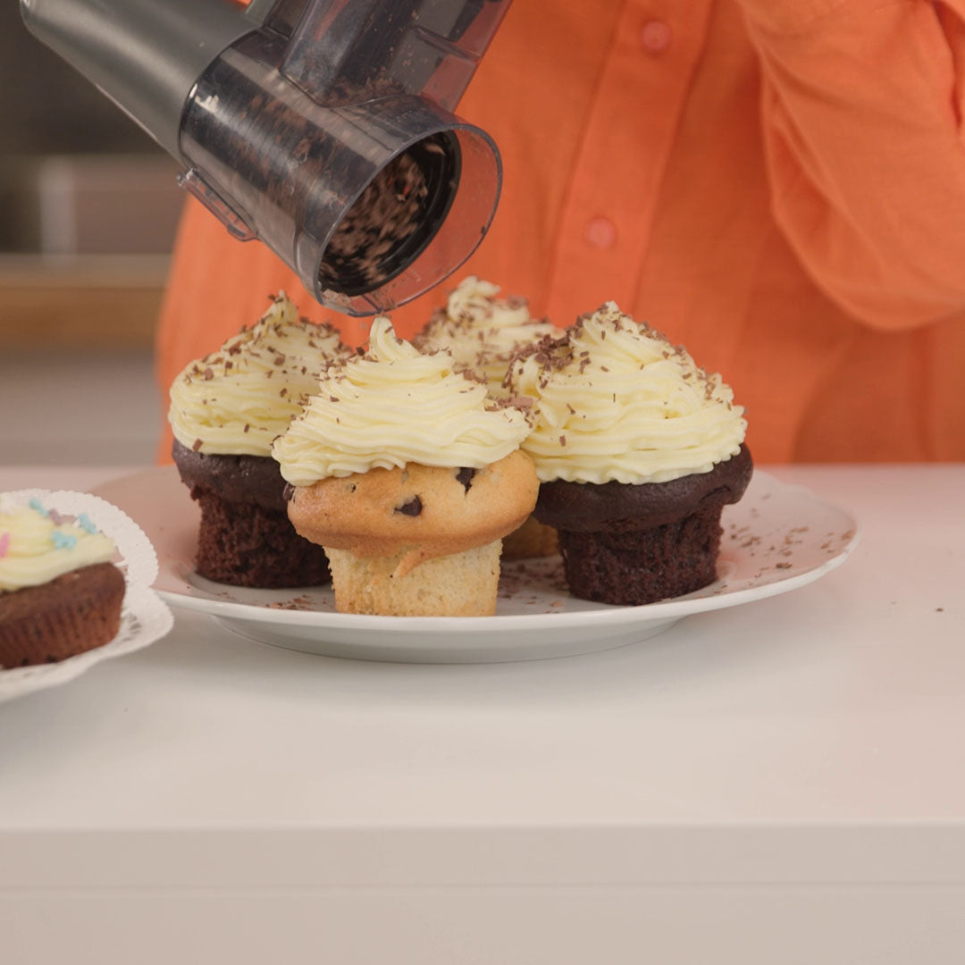 Küchengerät streut Schokoraspel auf Cupcake