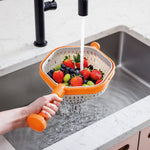 Hand hält Sieb über Abwaschbecken unter fließendes Wasser und wäscht Früchte.