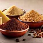 Gemahlene Nüsse, Parmesan und Kakaopulver in Schalen