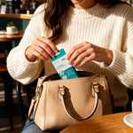 Frau steckt eine Packung ClicSwab Lippenpflege in ihre beige Handtasche – ideal für unterwegs