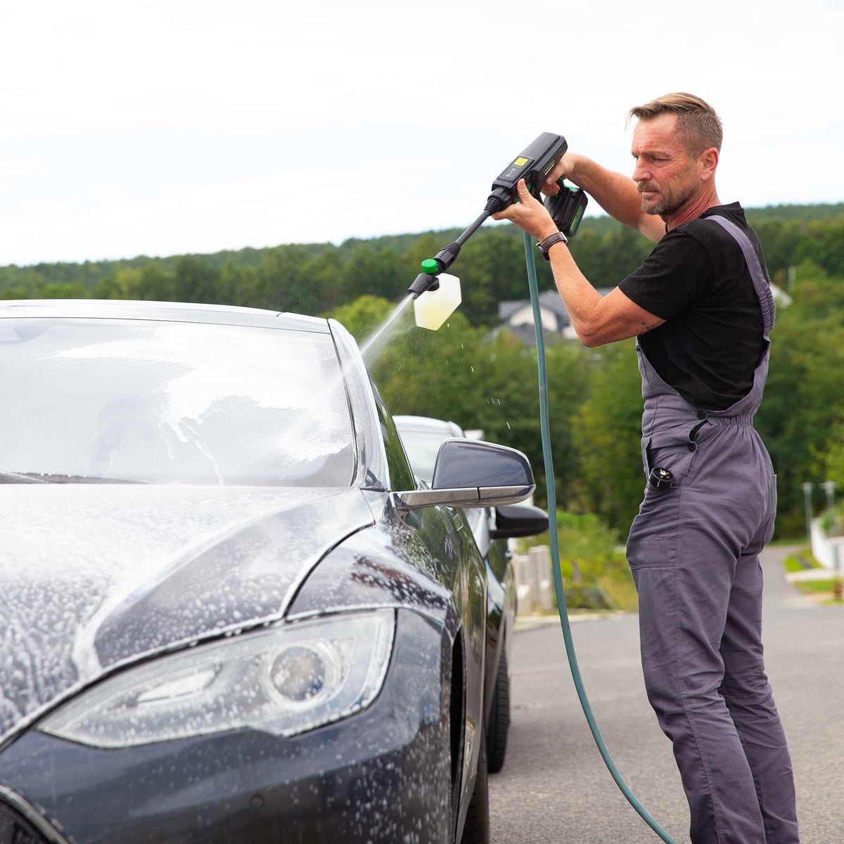 Mann wäscht ein Auto mit dem Hammersmith HydroBlast MAX und Schaumaufsatz