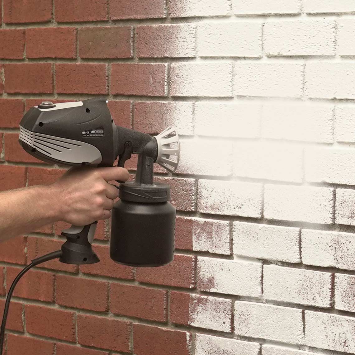 Rote Backsteinwand wird mit Hammersmith PaintBlast gleichmäßig weiß übergesprüht.