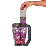 Hand schiebt Rotkohl in den PowerXL SenseMax, der das Gemüse fein zerkleinert.