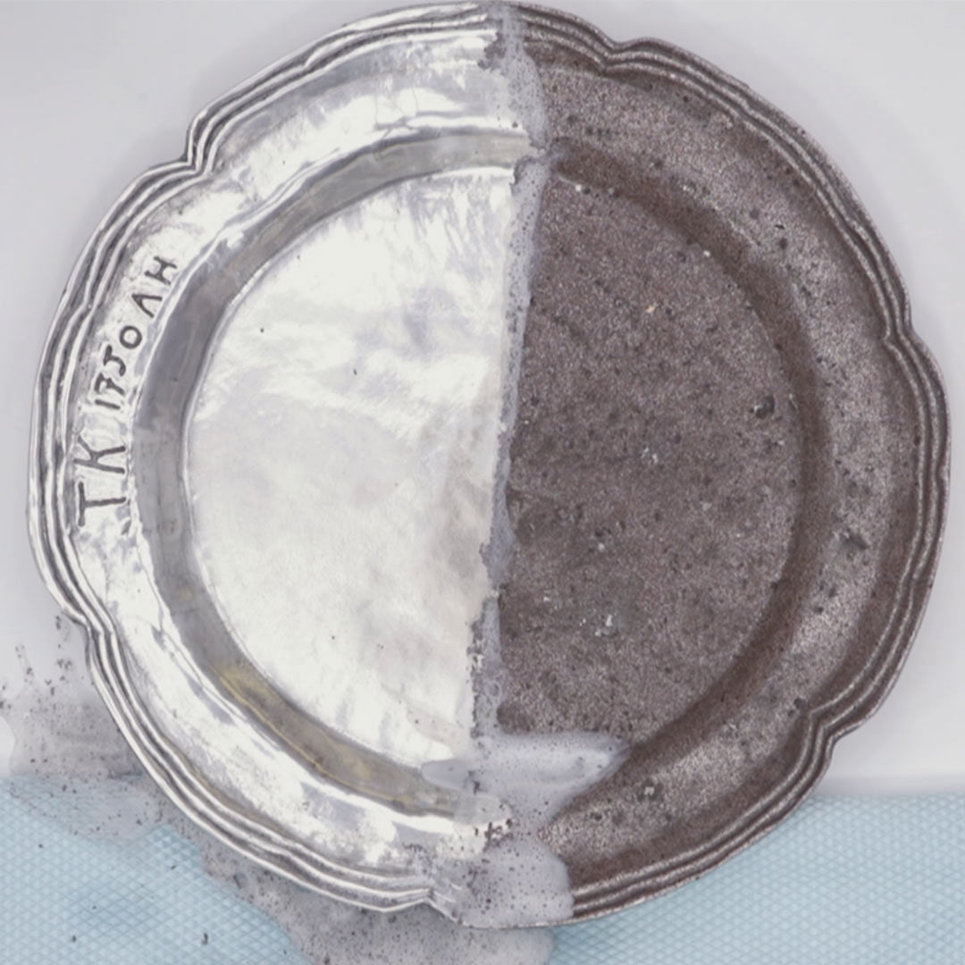 Mit Magic Shine halb gereinigter Zinnteller: links glänzend sauber, rechts noch dunkel und oxidiert