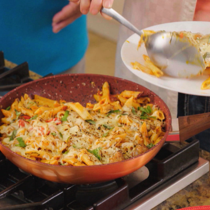 Aus der Copper and Stone Pan wird überbackene Pasta mit Käse auf einen Teller serviert.