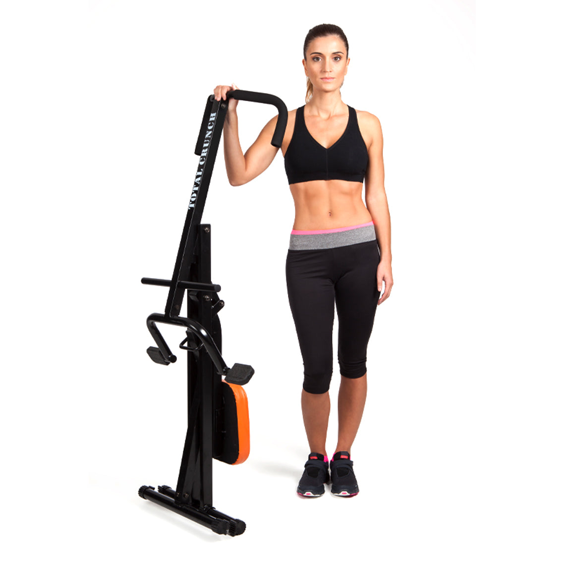Frau steht neben zusammengeklapptem Total Crunch – platzsparend und ideal für das Heimtraining.
