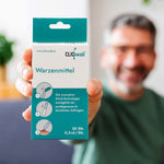 Mann hält eine Packung des ClicSwab Warzenmittels in die Kamera, im Vordergrund klar sichtbar die Produktverpackung