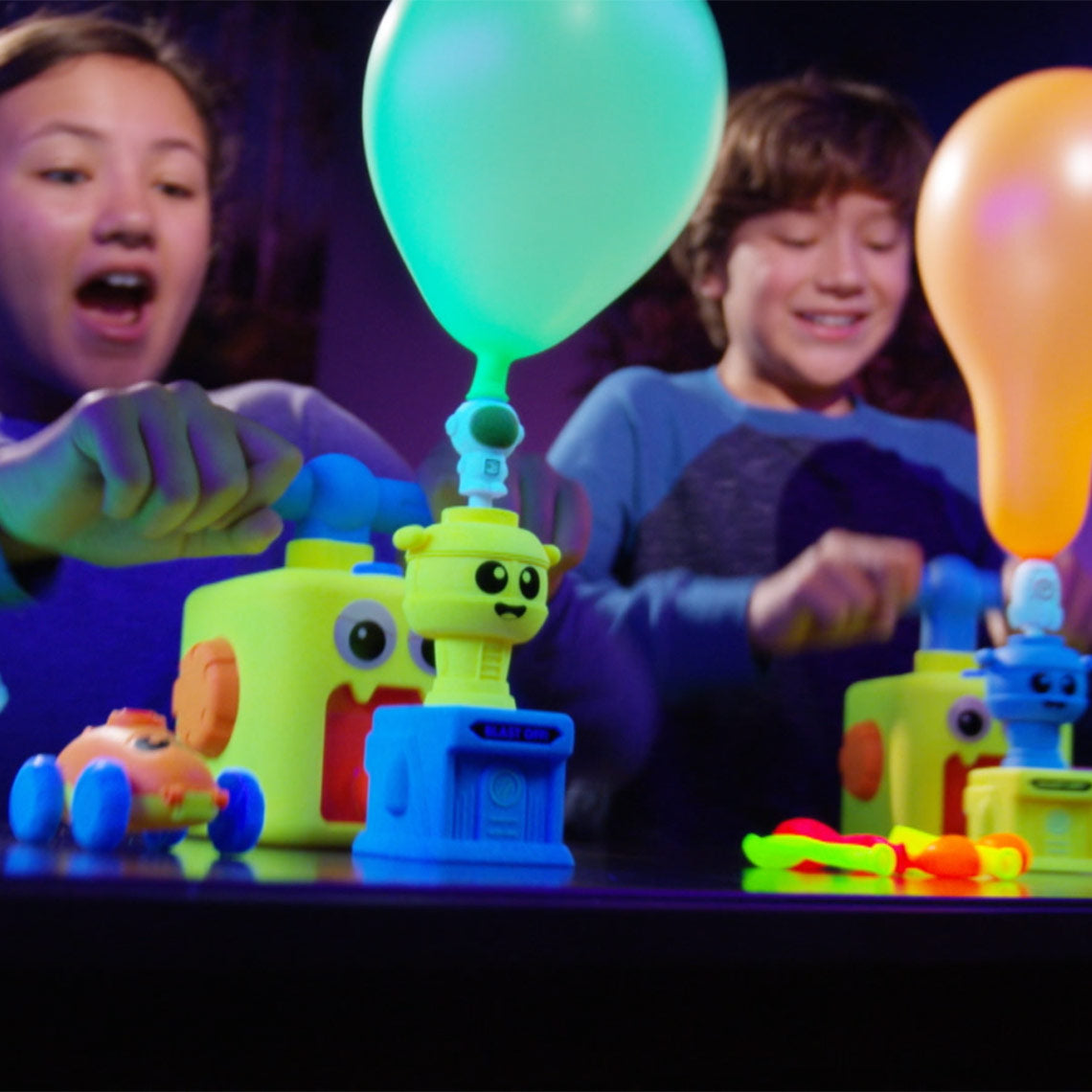 Kinder pumpen Ballons auf und starten ihre Fahrzeuge mit Balloon Zoom.