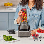Frau bereitet einen Smoothie zu und füllt den PowerXL SensiMax Mixbehälter