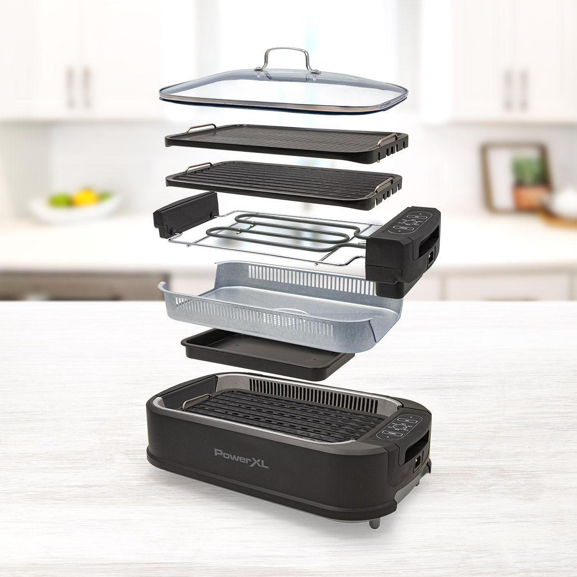 PowerXL Smokeless Grill – Explosionsdarstellung aller Teile: Glasdeckel, Grillplatten, Lüfter, Fettwanne und Gehäuse.