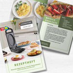 Rezeptheft mit Küchengerät auf dem Titel und abgebildeten Gerichten wie Omeletts und Pancakes auf einem hellen Holztisch.