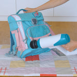 Person reinigt mit dem Livington SteamBuddy eine Schultasche gründlich mit heißem Dampf – ideal für hygienische Sauberkeit im Alltag