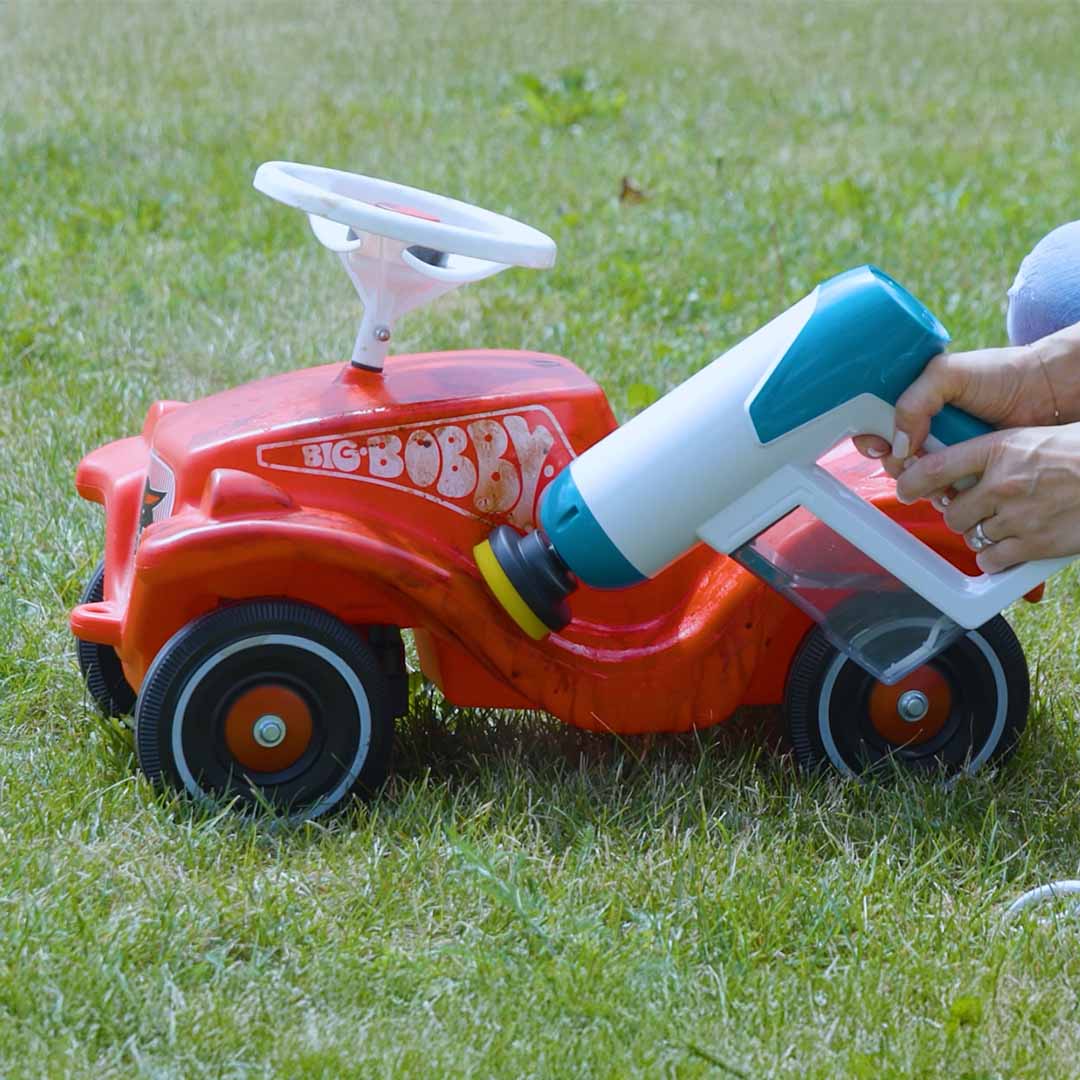 Livington SteamBuddy wird verwendet, um ein rotes Kinderfahrzeug zu reinigen – entfernt Schmutz und lässt Spielzeug wieder glänzen