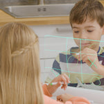 Zwei Kinder spielen Tic-Tac-Toe auf einer beleuchteten Mini-Leuchttafel.
