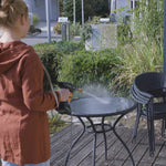 Mit dem Hammersmith HydroBlast wird ein Gartentisch im Außenbereich mit Wasser abgespritzt.