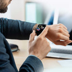 Ein Mann in Businesskleidung bedient den Kendox LifeTracker am Handgelenk im Büro.