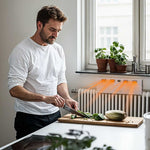 Livington SmartAir Heater am Heizkörper, Mann schneidet Gemüse in der Küche.